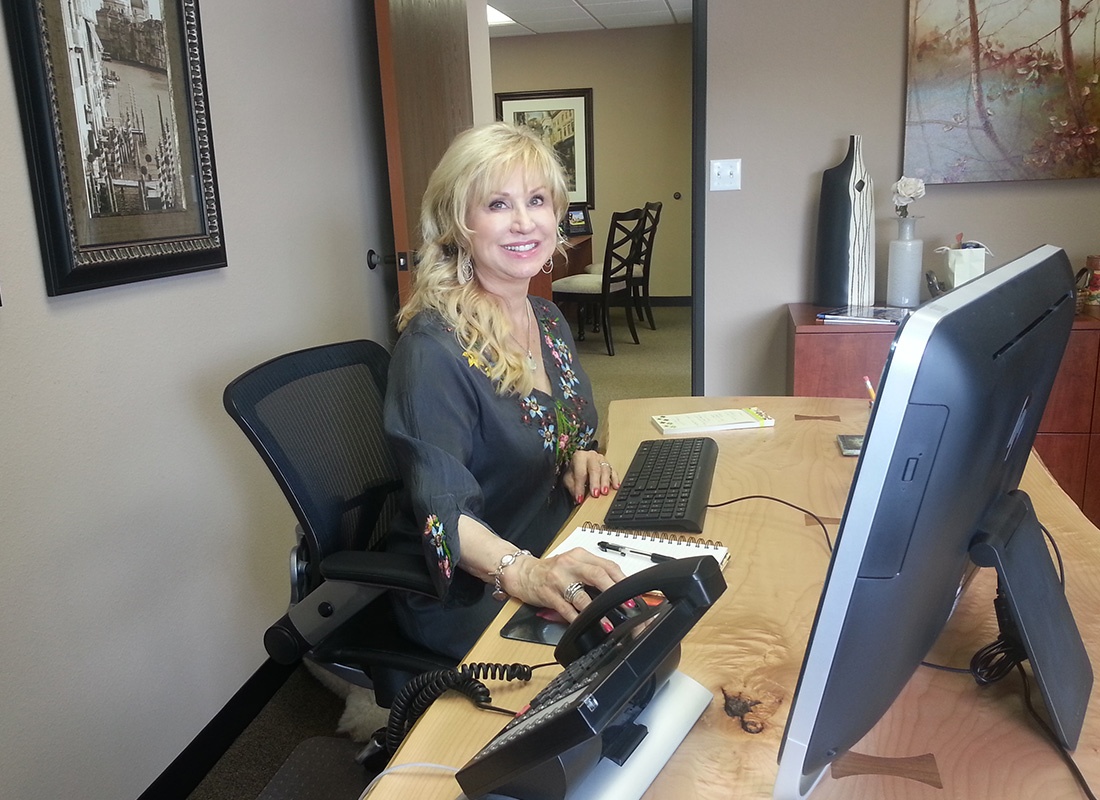Contact - Cheerful Female Business Owner from Huggins Dreckman Insurance Agency Inc Working at Her Desk