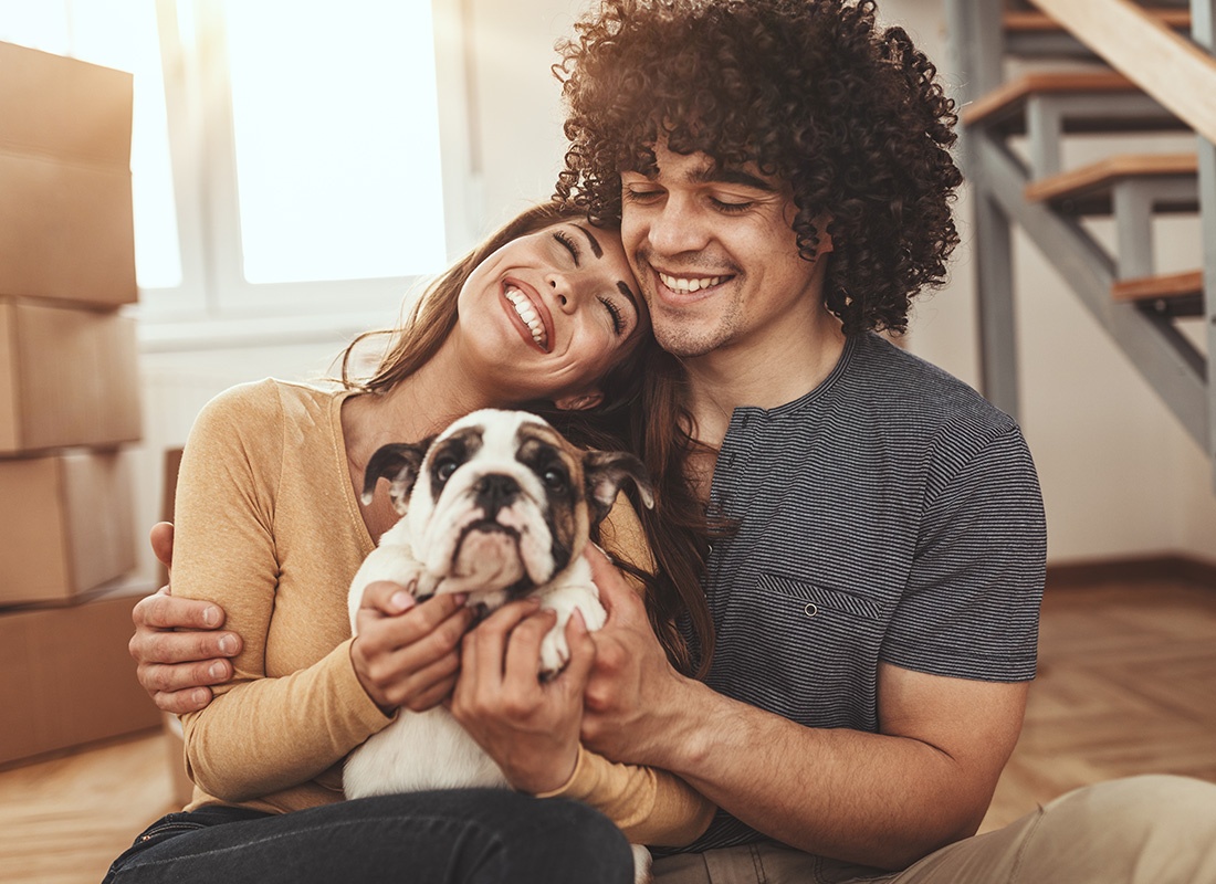 Personal Insurance - Happy Young Couple Enjoying First Apartment Together With an Adorable Puppy