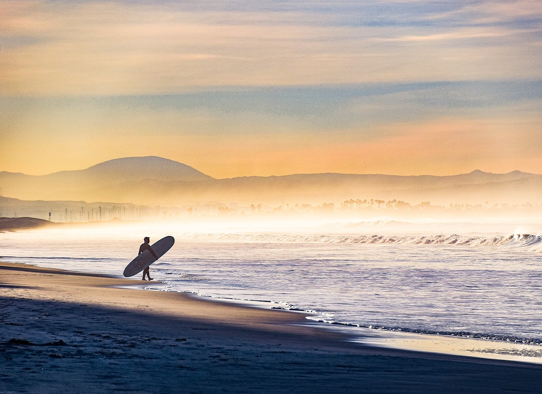 Read Our Reviews - View From the Distance of a Surfer Entering the Beach Waves on a Foggy Morning